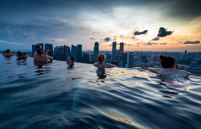 Просто глядя на купальщиков, наслаждающихся водными развлечениями и восхитительными видами за не огражденным бортом бассейна, становится не по себе (Marina Bay Sands, Сингапур). | Фото: bangkokbook.ru.