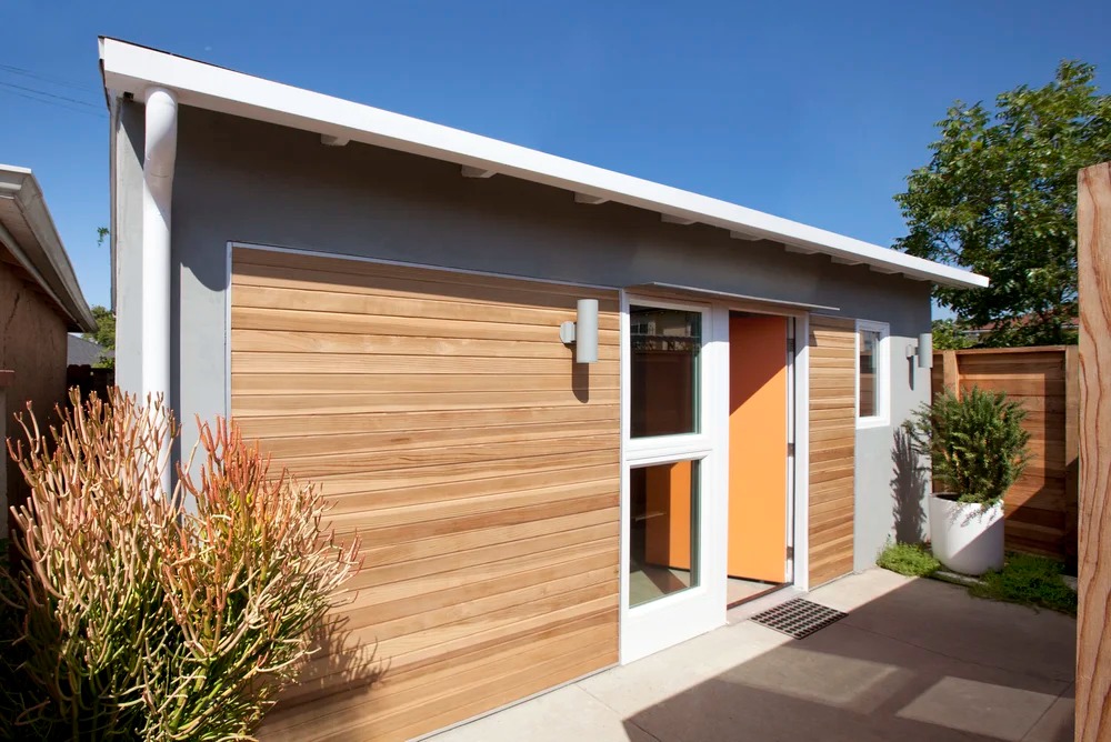 Лицевой фасад преображенного гаража обшит кедровыми досками (Ladera Heights ADU). Лицевой фасад преображенного гаража обшит кедровыми досками (Ladera Heights ADU).