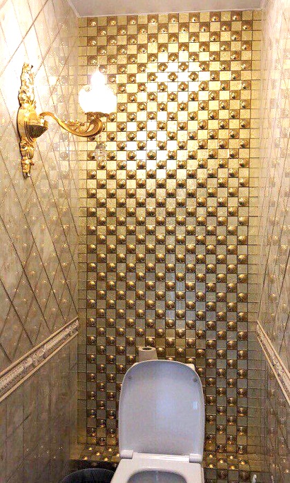 Стены в кабинках туалета украшены панелями с позолоченной лепниной.
