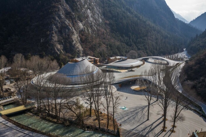 Плавно «раскручивающаяся» крыша, накрывает значительную часть территории, но не лишает возможности обустроить сады и клумбы (Jiuzhai Valley Visitor Center, Китай). | Фото: designboom.com.