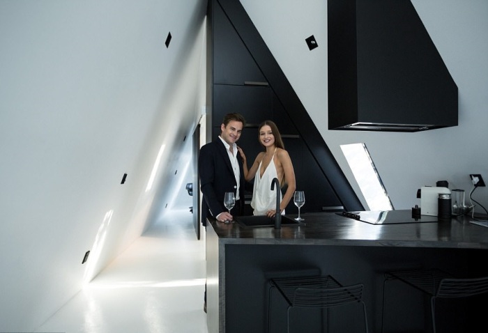 Архитектор Крис Тейт с подругой на фоне черной кухни, ставшей контрастным пятном в белом интерьере (The Tent House, Новая Зеландия). | Фото: designboom.com.