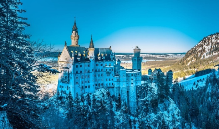 Замок Нойшванштайн особенно хорош в зимнюю пору, когда белые стены сливаются с заснеженными вершинами и кронами деревьев (Бавария). | Фото: theepochtimes.com.