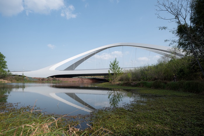 Монолитная арочная конструкция моста позволила отказаться от установки опор на дне реки (West Line Road Chengdu, Китай). | Фото: parametric-architecture.com.