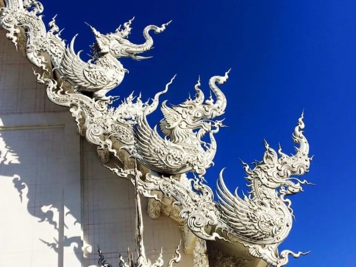 Крышу «Белого храма» украшают стилизованные символы, олицетворяющие 4 стихии (слон символизирует землю). <br>| Фото: discoverwalks.com.