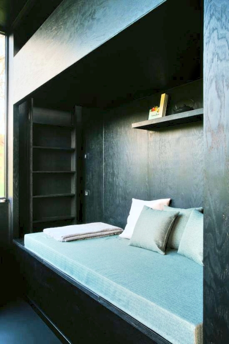 Из зоны гостиной можно попасть на второй уровень, где предусмотрено дополнительное спальное место с потолочным окном (Raus Cabin, Германия). | Фото: decor.design.