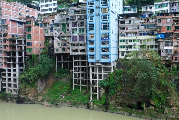 Высотные дома Яньцзиня граничащие с рекой, всегда строят на опорах, чтобы спасти первые этажи от постоянных затоплений ( Китай). | Фото: euroweeklynews.com.