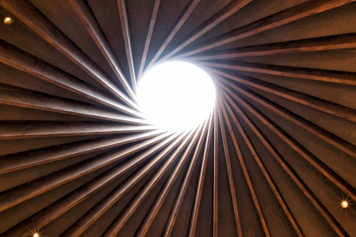 Закручивающиеся к потолку грани, сходятся вокруг круглого потолочного люка, пропускающего солнечный/лунный свет и мерцание звезд (The Underground Library, Япония). | Фото: spoon-tamago.com.