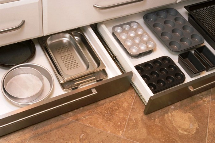 Выдвижные ящики в цоколе кухне помогут разместить много нужных вещей.