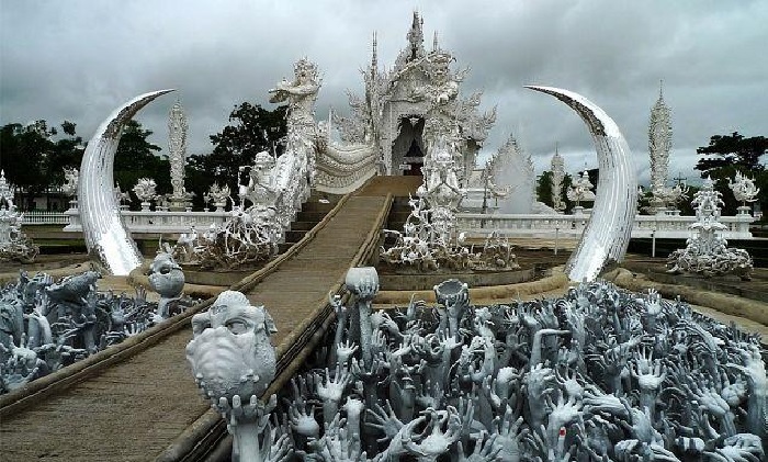 Перед мостом посетителей ждет жуткое испытание, которое должно заставить задуматься о дальнейшем пути (The White Temple, Таиланд). | Фото: discoverwalks.com.