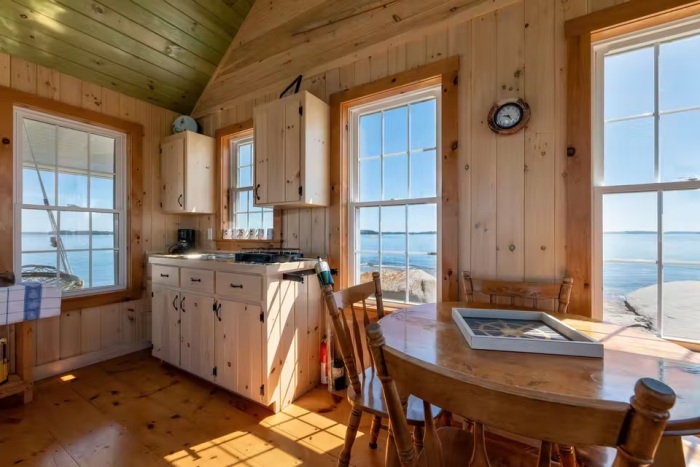 Кухня и обеденная зона в одиноком коттедже на частном острове (Duck Ledges Island, США). | Фото: boldcoastpropertiesllc.com.