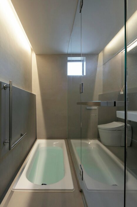 Чтобы расширить пространство узкой ванной комнаты, шкаф установили с зеркальным фасадом (Murakoshi House, Япония). | Фото: kqeducationgroup.com.