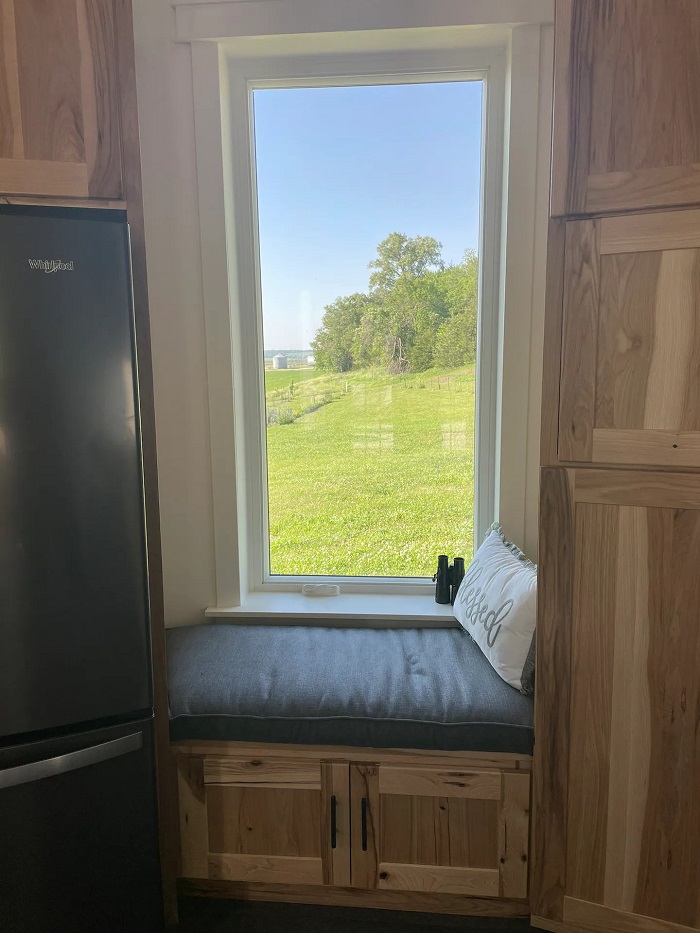 Большое панорамное окно со скамейкой для чтения — идеальное место для отдыха и расслабления (Grain Bin Getaway). Большое панорамное окно со скамейкой для чтения — идеальное место для отдыха и расслабления (Grain Bin Getaway).