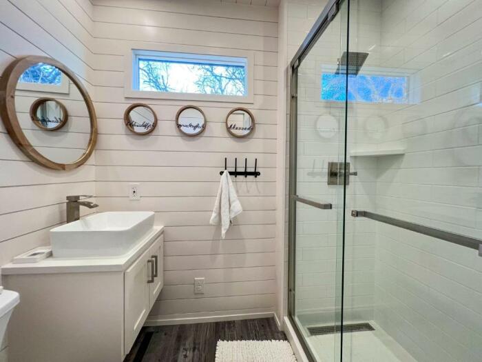 В ванной комнате имеются: тропический душ, унитаз, раковина и стирально-сушильная машина, что добавляет функциональности пространству (Flagship, США). | Фото: livinginacontainer.com.