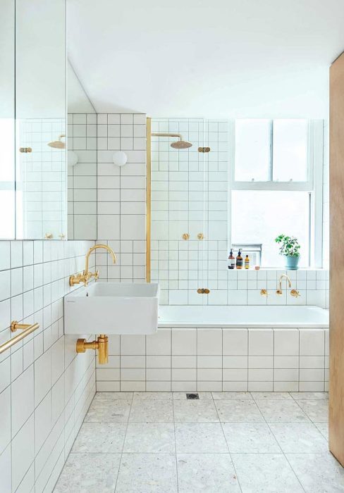 Белый кафель и большие зеркала сделали ванную комнату светлой и просторной. | Фото: interiorizm.com.