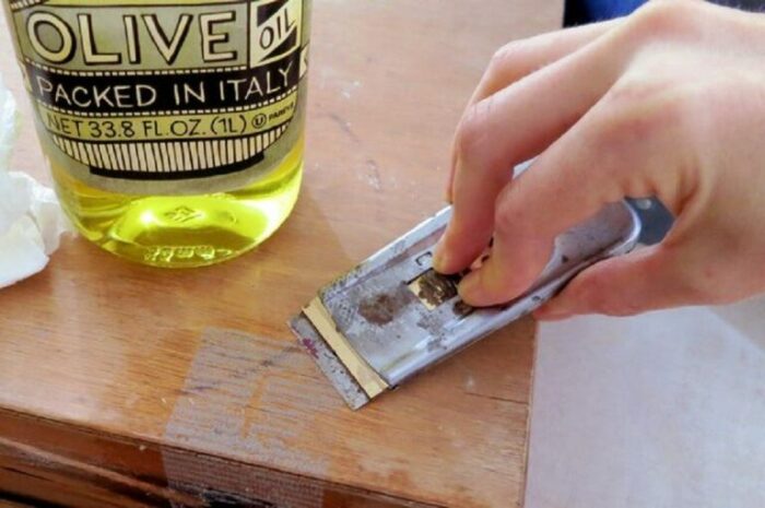 На оставшийся клей наносим равномерно масло и через несколько минут снимаем наклейку при помощи ножа / Фото: severdv.ru