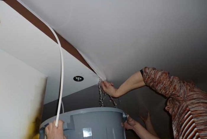 Чтобы слить воду, отверните уголок полотна, а не прокалывайте потолок / Фото: ignes-fatui.ru