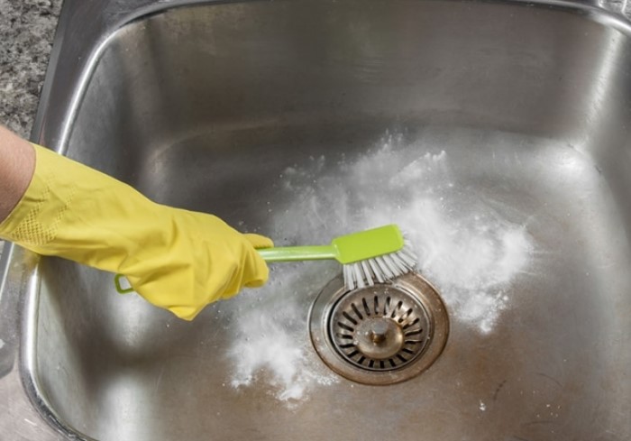Чтобы лучше отчистить места около крана и слива, воспользуйтесь щеткой / Фото: poradu.com.ua