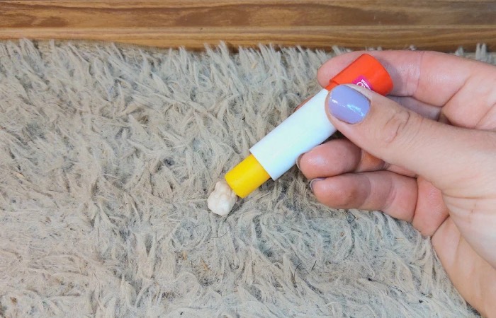 Обычная гигиеническая помада поможет спасти ковер.