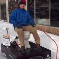 Американец расчищает снег на улице, сидя на унитазе